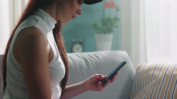 Woman In Hat Is Using Mobile Phone