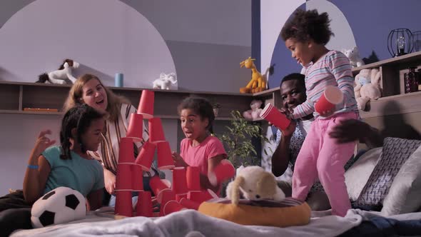 Diverse Dad and Mom Playing with Children on Bed