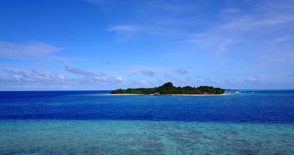 Wide overhead island view of a white paradise beach and blue sea background in hi res 4K