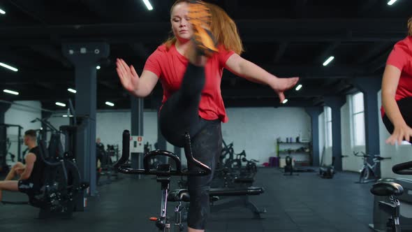 Group of Girls Performs Aerobic Training Workout Cardio Routine on Bike Simulators Cycle Training