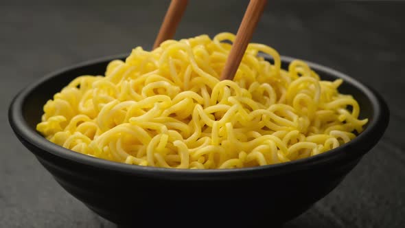Instant noodles with chopsticks on black background, ProRes uncompressed