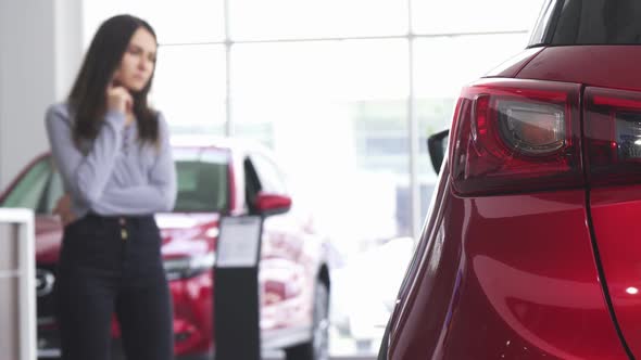 Female Customer Choosing a New Car at the Dealership Salon