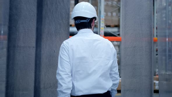 Employee male warehouse worker engineer man in hard hat working at construction site warehouse