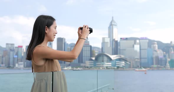 Woman taking photo on Victoria harbor in Hong Kong 