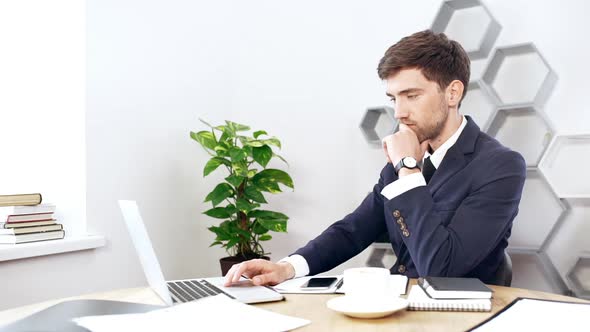 Young Successful Businessman Working at Laptop in Office