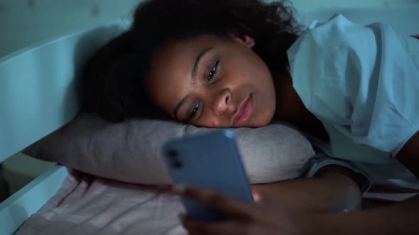 Confident girl looking at phone at night