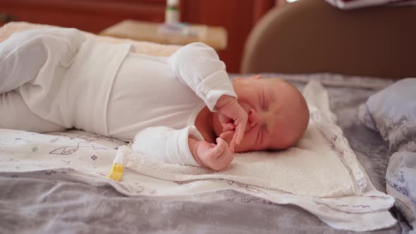 Cute Newborn Baby Lies on a Diaper and Cries