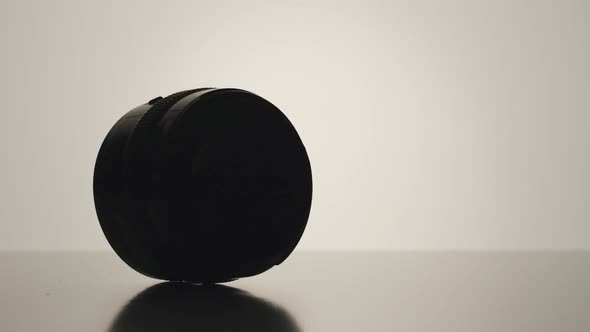 SLOW MOTION: Camera lens spinning on the white surface