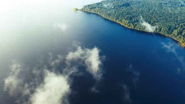 Aerial view white clouds over blue sea and forest. Clouds in motion.