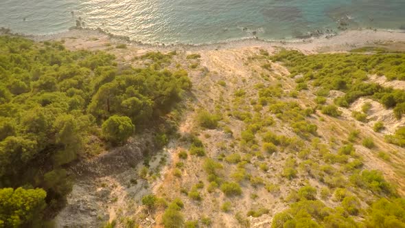 Aerial view of dirt road leading to beautiful paradise beach in Greece.