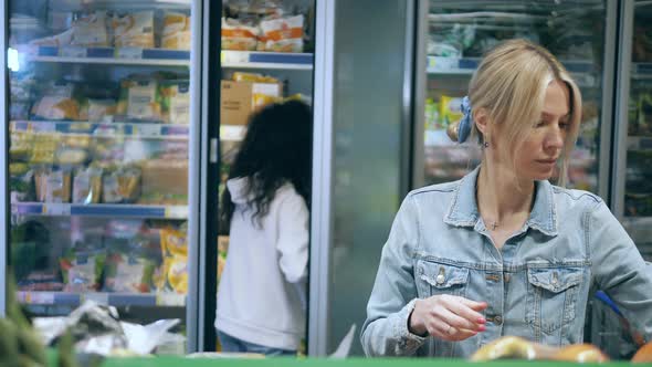 Women are Shopping for Fruits and Frozen Food in the Store