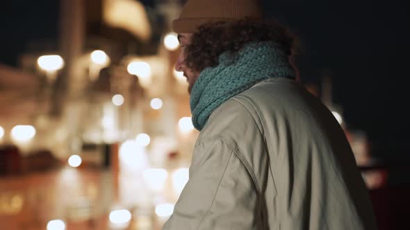 Handsome curly-haired man looking at view outdoors