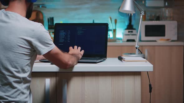 Male Hacker Typing on Keyboard Wearing Headset Working From Home