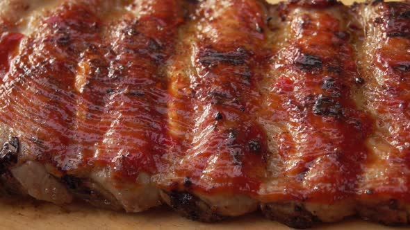 Closeup of Kitchen Brush Smearing Spiced Delicious Ribs with Tomato Sauce