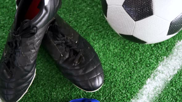 Football, medal and cleats on artificial grass 4k