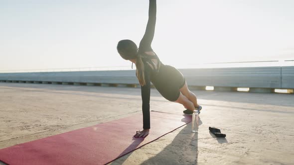 Sportswoman Doing Side Plank on Embankment