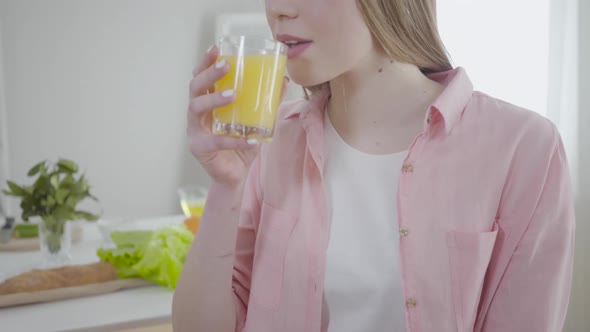 Unrecognizable Cute Girl Drinking Orange Juice and Smiling at Camera