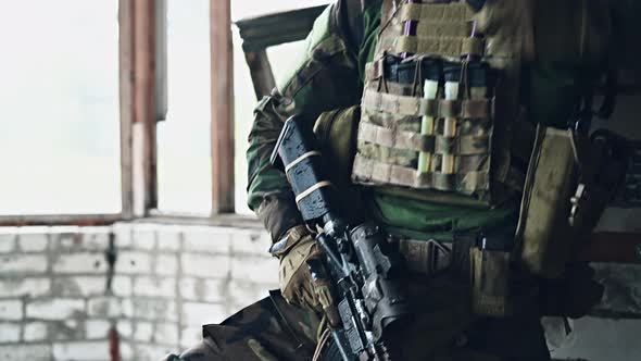 Front View Close Up of Caucasian Soldier with a Rifle Stand Guard Securing Territory Looking Around.