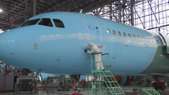 Painting the aircraft at the factory. The engineer repairing the aircraft