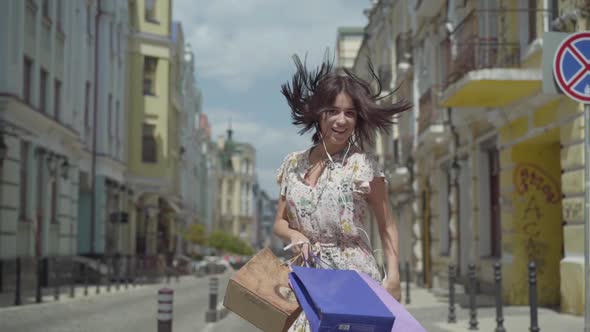 Cute Cheerful Young Woman with Shopping Bags