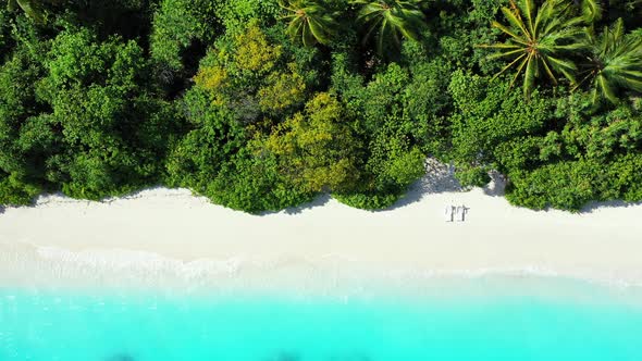 Daytime aerial island view of a white paradise beach and aqua blue water background in colorful 4K