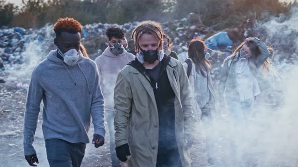 Group of Young Volunteers in Gas Masks Take Care of the Environment