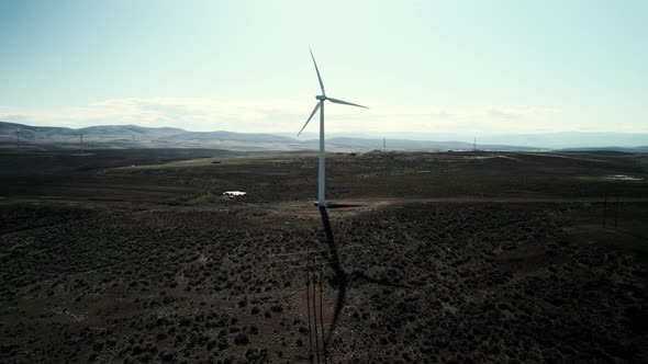 Slowly orbiting a single wind driven turbine in the high desert, aerial