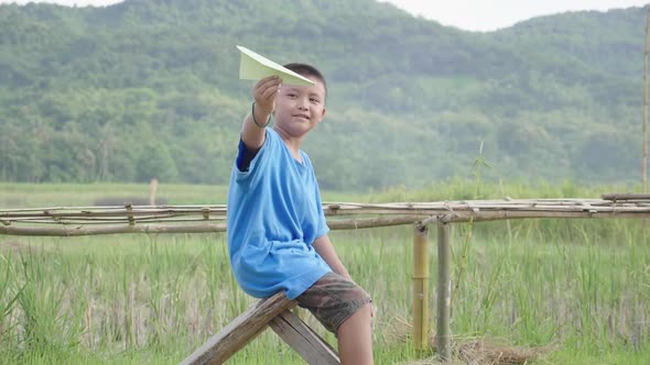 Asian Rural Boy Playing With Paper Airplane