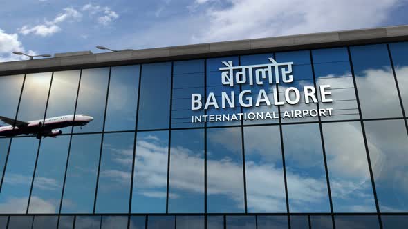 Airplane landing at Bangalore India airport mirrored in terminal