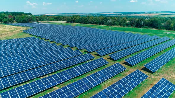 Aerial View. Flying Over The Solar Power Plant With Sun. Solar Panels And Sun.