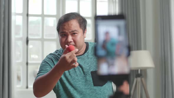 Asian Man Blogger Shoots Video Content For Social Networks By Smartphone, Magician With Red Ball