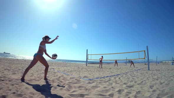 POV of women players playing beach volleyball and serving.