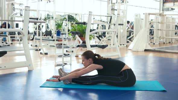 Girl Stretching on Mat at Gym.