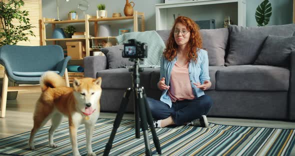 Slow Motion of Joyful Blogger Dog Owner Recording Video Using Modern Camera