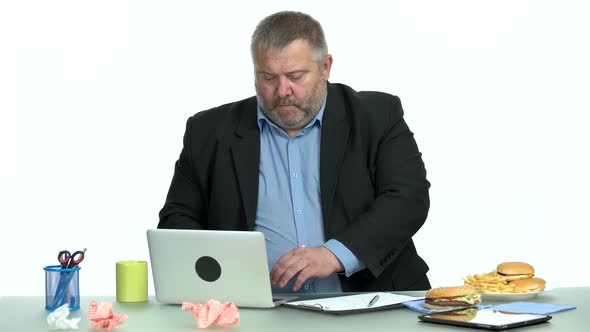 Businessman Eating Fast Food While Working at Office