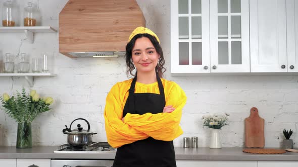 Portrait Smiling Housewife Looking Camera with Crossed Hands in Home Kitchen