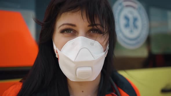 Dolly in Macro Female Paramedic Looks at you Near Ambulance Vehicle