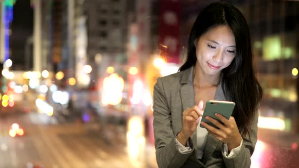 Woman Looking at Mobile Phone at Night 