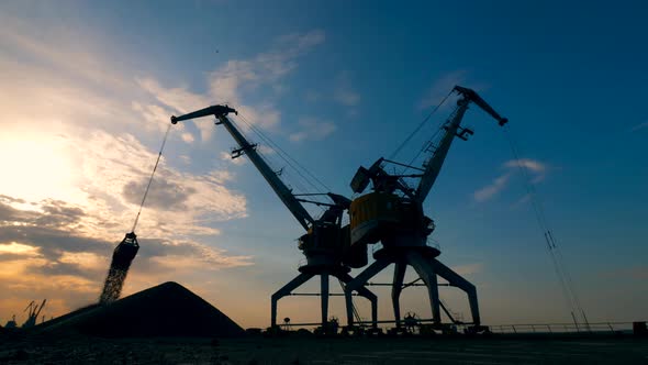 Sunset Landscape with Two Excavators Relocating Rubble