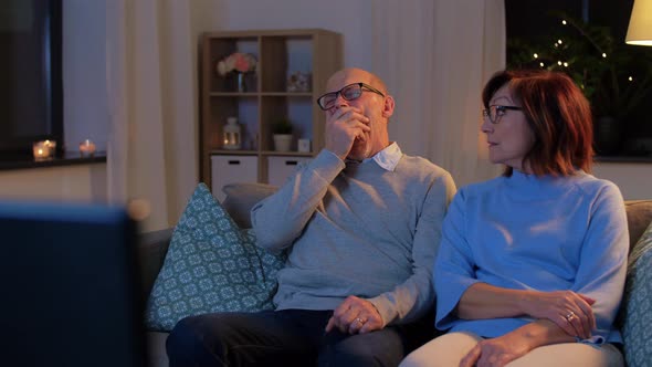Senior Couple Turning Tv Off at Home in Evening