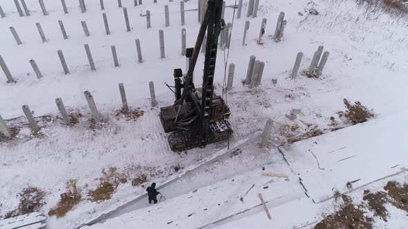 Pile bore machine lifts a reinforced concrete pile with a cable 15