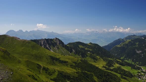 Slow Panement right over the lush green mountain in the Alps of Liechtenstein, aerial view over the