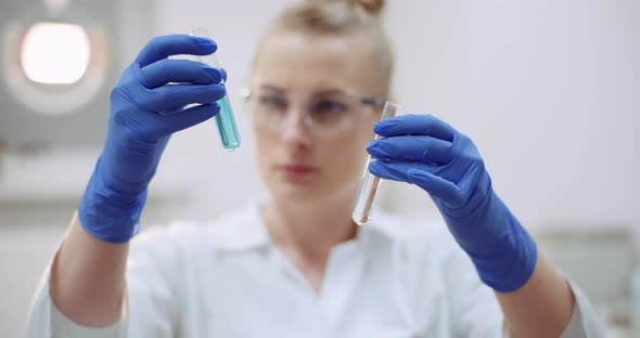 Portrait of Female Scientist with a Pipette Analyzes a Liquid To Extract the DNA in Lab