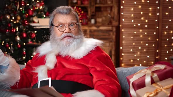 Portrait of Amazed Santa Claus with Natural Beard Read Xmas Wish List