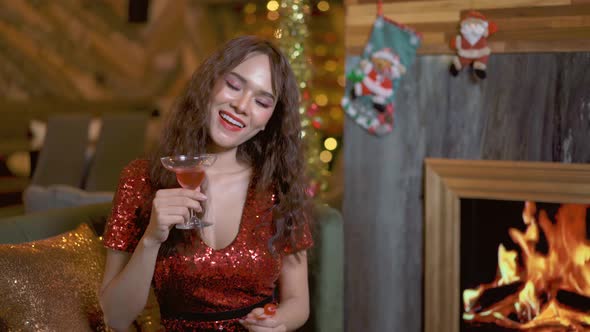 Young asian girl in red dress with cocktail in hands she is drinking and dancing in club or bar