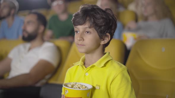 Cute Middle Eastern Boy Showing Hush Gesture in Cinema. Portrait of Happy Little Kid Enjoying Film