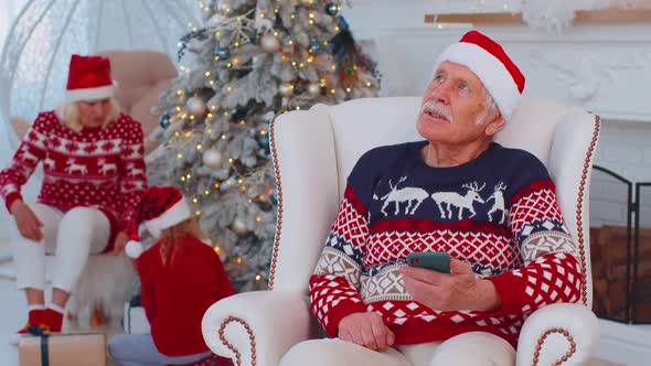 Senior Old Grandfather Man Buy Christmas Gift Presents Doing Online Shopping on Smartphone at Home