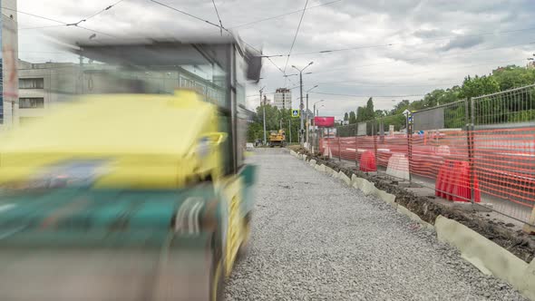 Green Vibration Roller Compactor Rolls on a Stones at Road Construction and Repairing Timelapse