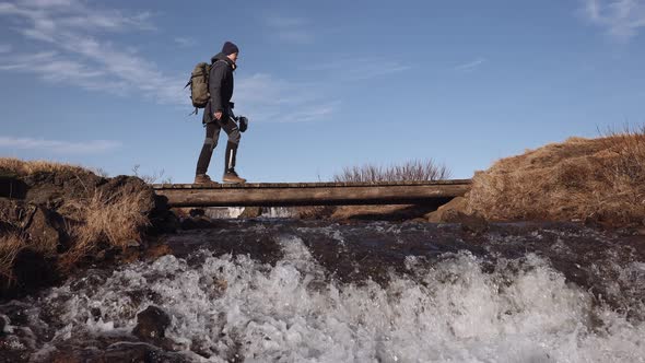 Bottom Up View on Cascades of Fast Flowing River Under Little Wooden Bridge