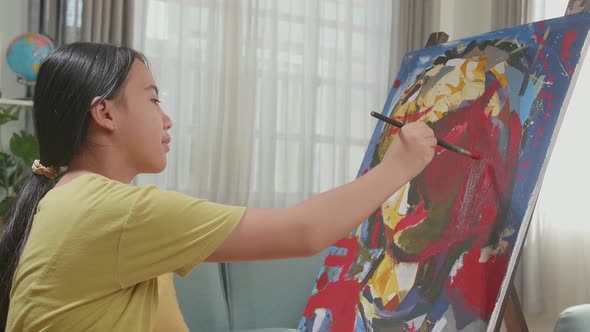 Medium Shot Side View Of An Asian Artist Girl Holding Paintbrush Mixed Colour And Painting